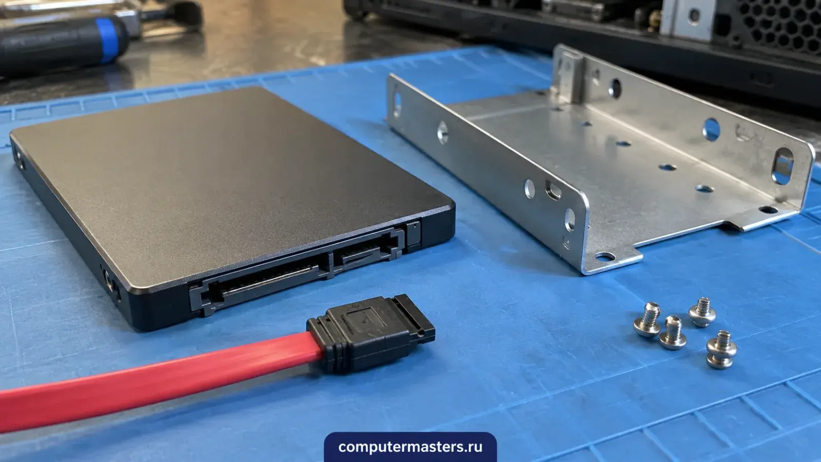 SSD 2,5 дюйма с разъёмами SATA, красный кабель данных, металлические салазки и винты на синем коврике