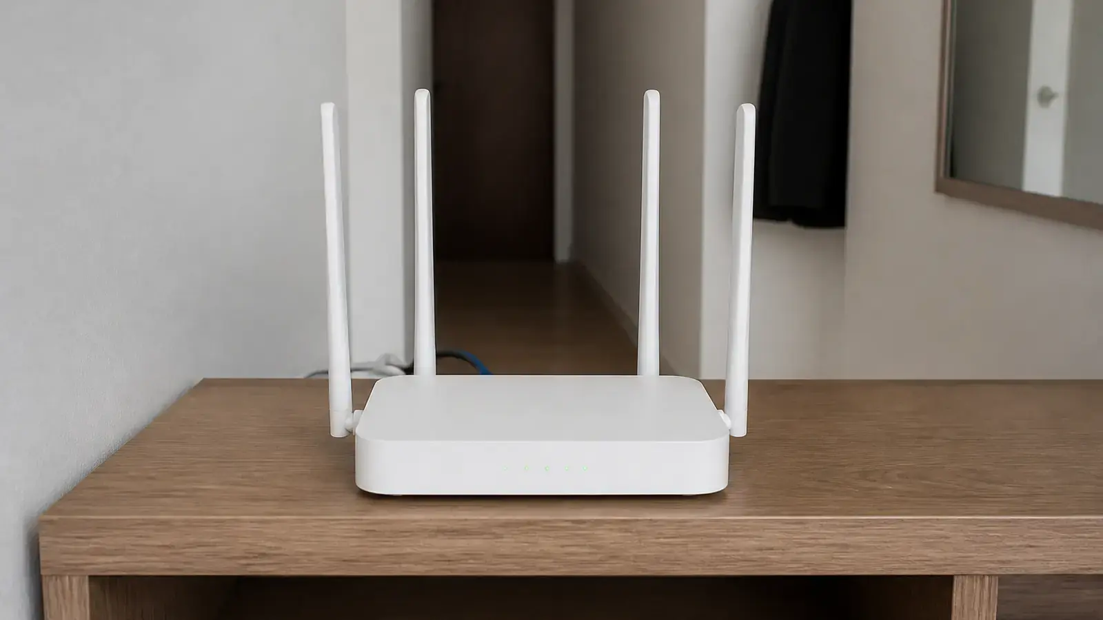 Белый домашний Wi-Fi роутер с четырьмя внешними антеннами стоит на деревянной полке в коридоре, от задней стенки отходят кабели